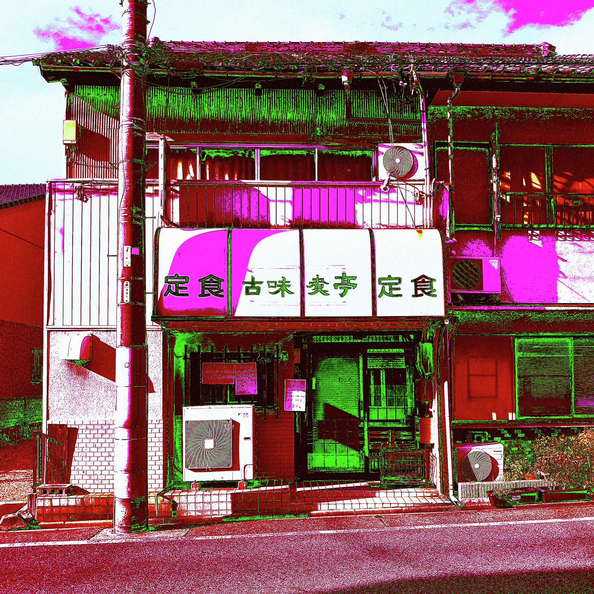 White Japanese sign panels span a brightly tinted restaurant frontage with exposed air-conditioning units and upper windows.
