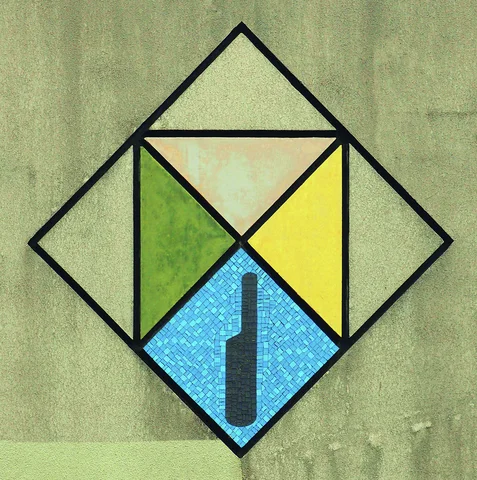 A geometric diamond mosaic contains colored triangles and a dark symbol within its blue lower section.
