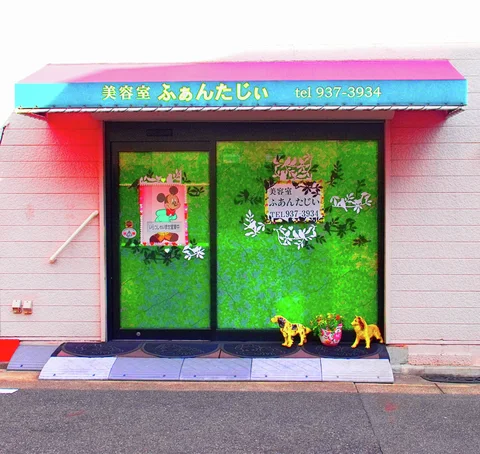 Green decorated salon doors stand beneath a turquoise awning with small animal figures outside.