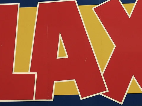 Large red letters outlined in white fill a yellow sign with dark blue borders.