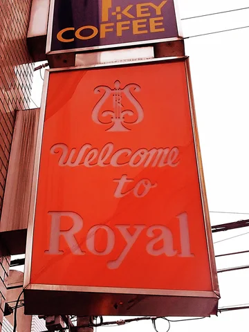 A red Welcome to Royal sign hangs beneath a smaller dark KEY COFFEE panel.