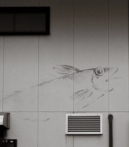 A faint bird-head drawing spreads across a pale paneled wall above a rectangular vent.