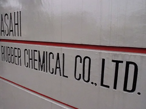 Narrow black RUBBER CHEMICAL CO LTD lettering spans pale metal panels separated by red horizontal trim.