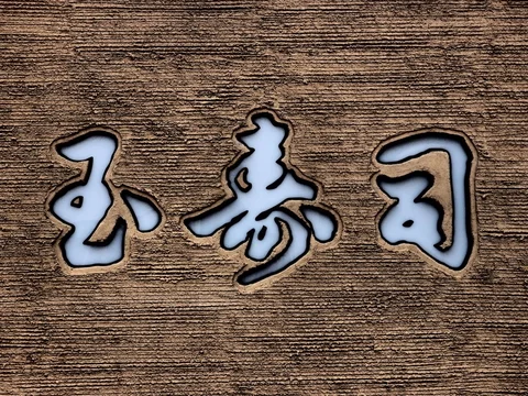 Three pale inset characters outlined in dark trim mark a textured brown wall.