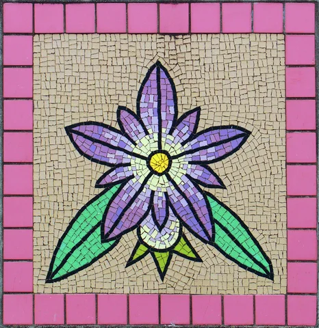 A purple flower with a yellow center and green leaves forms a mosaic bordered by pink tiles.