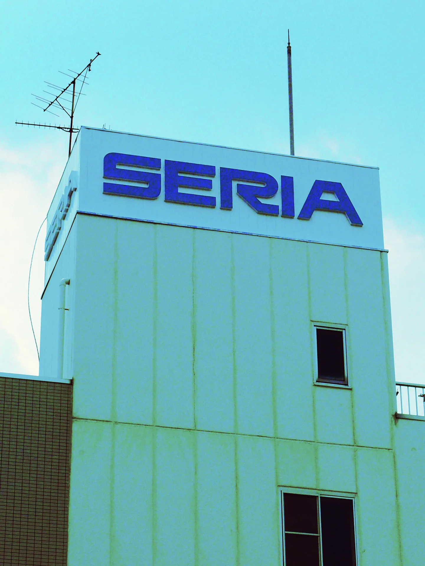 Blue SERIA lettering tops a narrow pale tower with antennas and small dark windows.