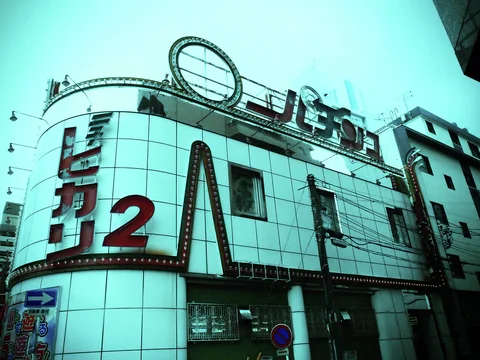 A curved tiled building displays a large red 2 beneath a rooftop oval emblem and lettering.