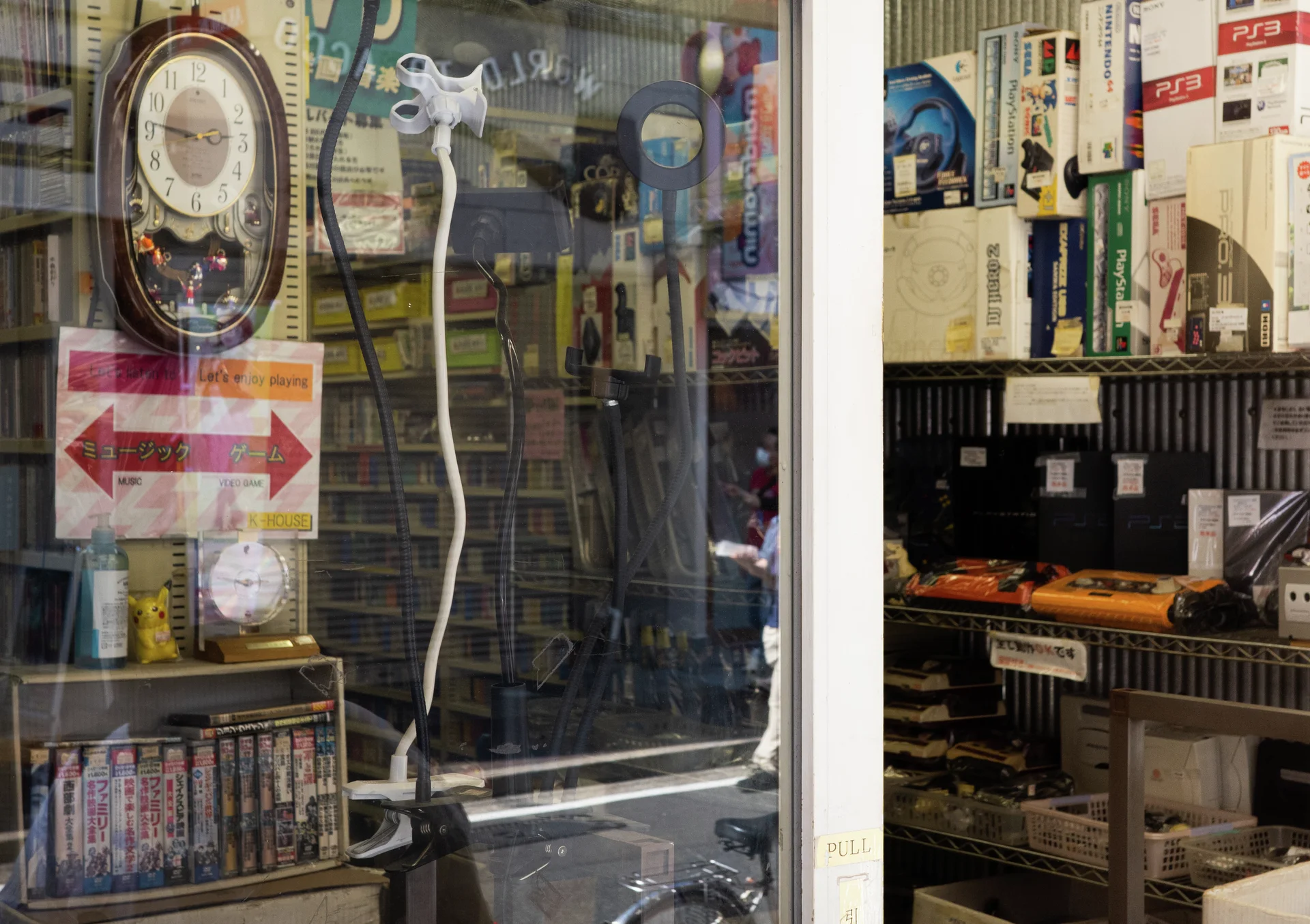 A shop window displays an ornate clock, shelves of books, and a red directional arrow.