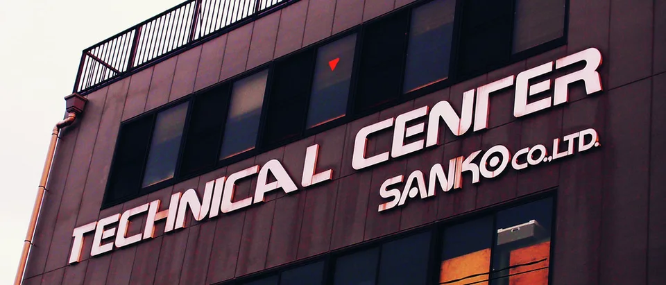 Large pale Technical Center lettering spans a dark building facade beneath a row of windows.