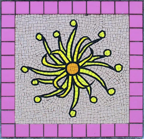 A yellow curling flower mosaic radiates from an orange center within a pink tile border.