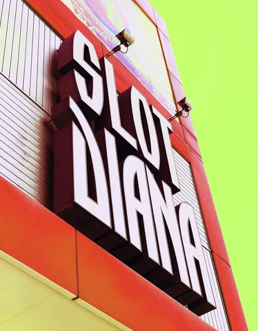 Large pale slot lettering projects from a red-orange building facade against a bright green sky.