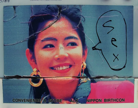 A weathered advertisement shows a smiling woman with hoop earrings beside a handwritten speech bubble.