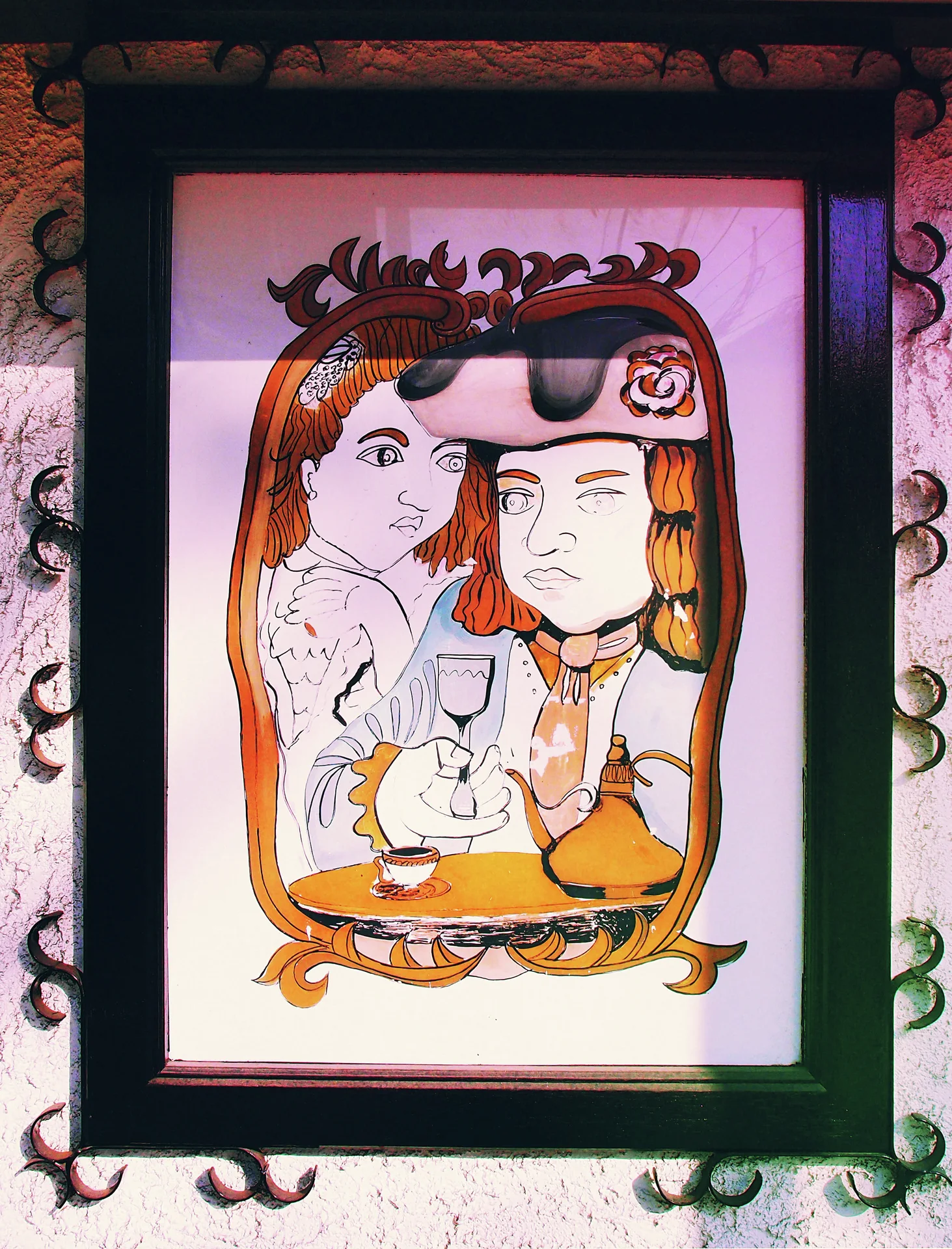 A framed cartoon shows two figures with a cup beneath an ornate golden border.