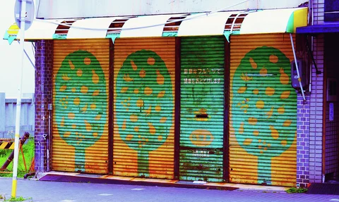 Painted green trees with yellow oval leaves decorate orange shutters beneath a striped awning.