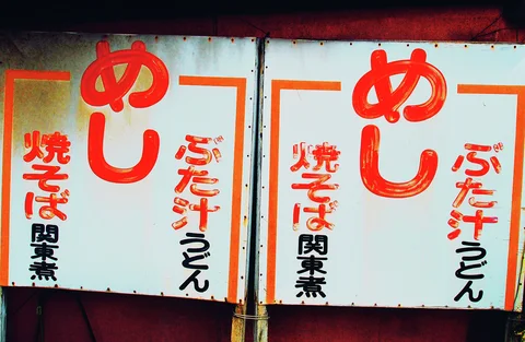 Two pale menu panels display large red Japanese characters above smaller black and orange lettering.