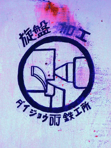 A dark circular technical diagram and Japanese lettering decorate a pale stained wall.