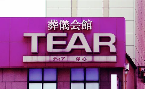 Large pale TEAR letters and Japanese characters project from a bright magenta building fascia.