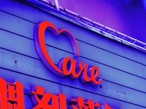 Red cursive lettering beginning with a heart-shaped outline projects from a violet horizontal-paneled wall.