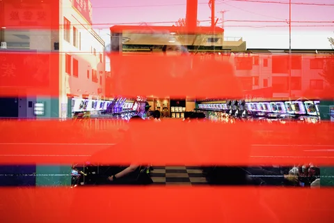 Broad red bands across glass overlay reflections of buildings and rows of brightly lit gaming machines.