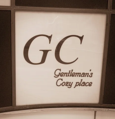 Large GC initials and smaller Gentleman窶冱 Cozy place lettering fill a pale framed sign panel.