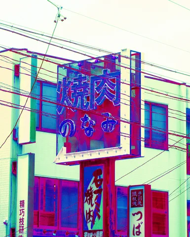 A large framed restaurant sign projects above smaller vertical signs behind a web of overhead cables.