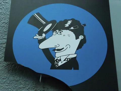 A cartoon man lifting a top hat fills a blue circular sign on a dark background.