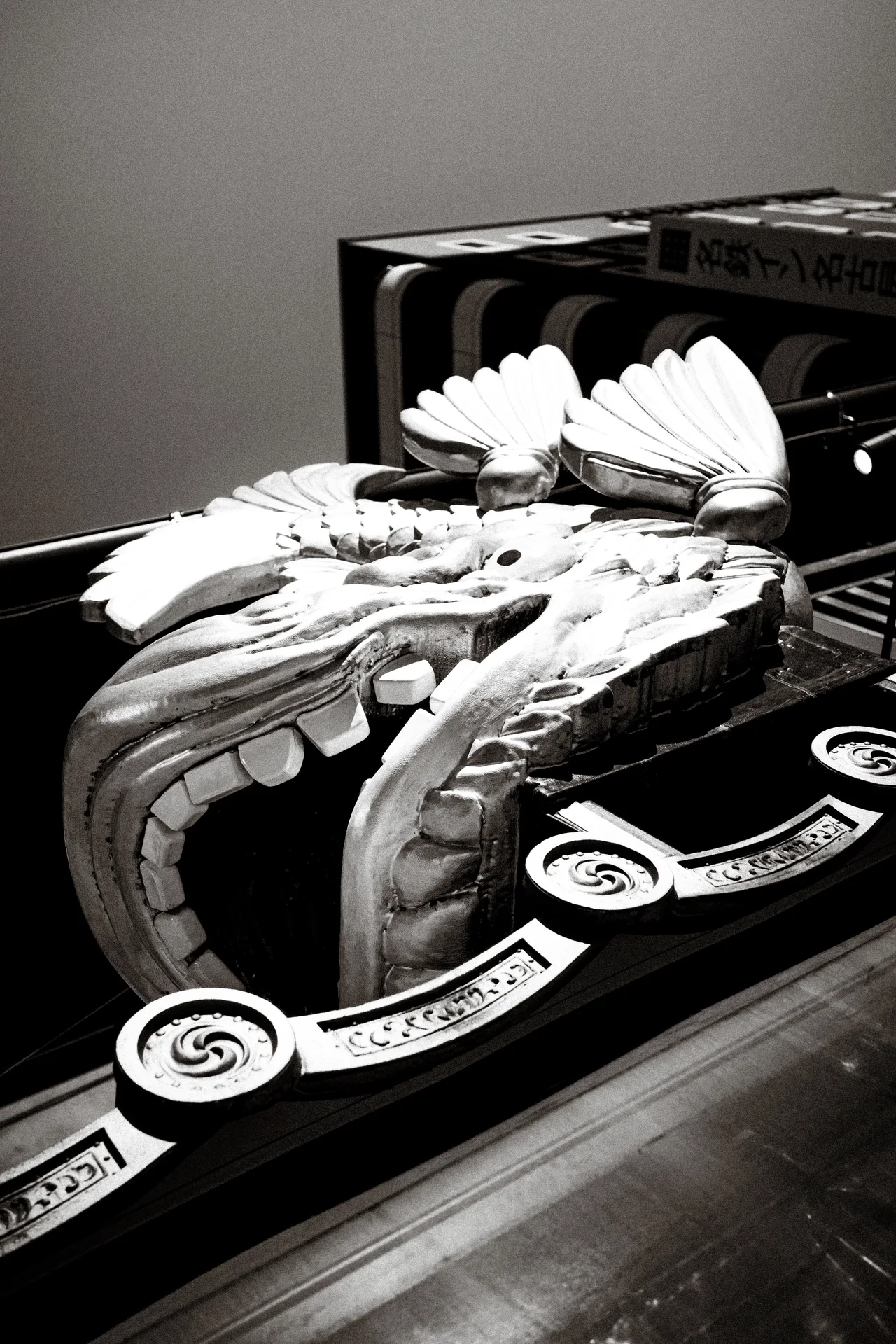 Two ornate curved roof ornaments rest on a decorative dark platform in black and white.