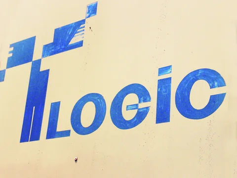 Large blue LOGIC lettering and a geometric symbol cover a pale wall with small visible surface marks.