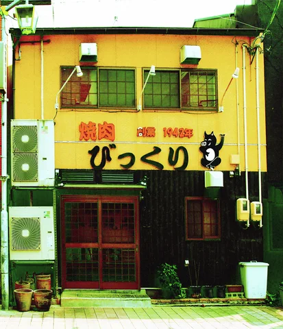 A yellow storefront displays bold black lettering and an animal graphic above dark windows and doors.