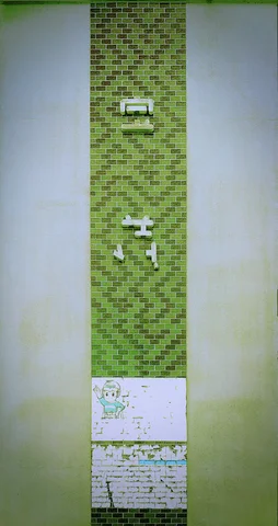 Small raised characters mark a narrow green mosaic-tiled strip between broad pale wall panels.