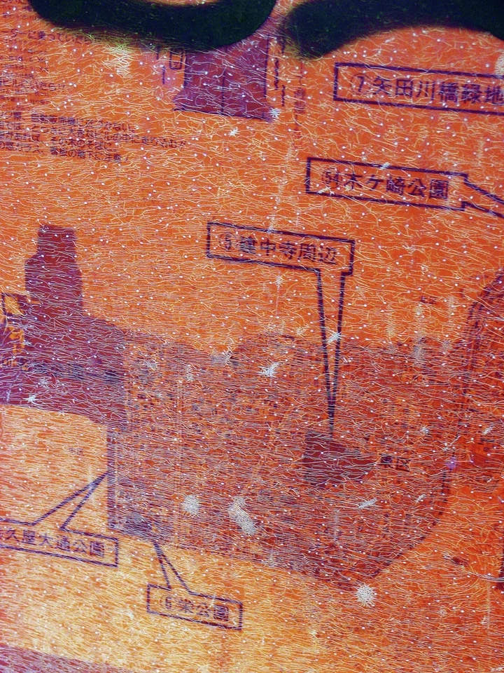 Faint purple labels and stepped lines cover a grainy orange surface with darker irregular patches.