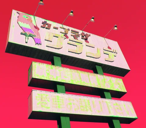 Three weathered sign panels rise on green posts beneath four lamps against a vivid red sky.